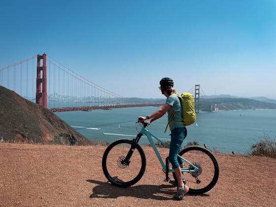 A biker stopped to take in the scenery on the fire road leading to Kirby Cove and overlooking the Golden Gate Bridge 