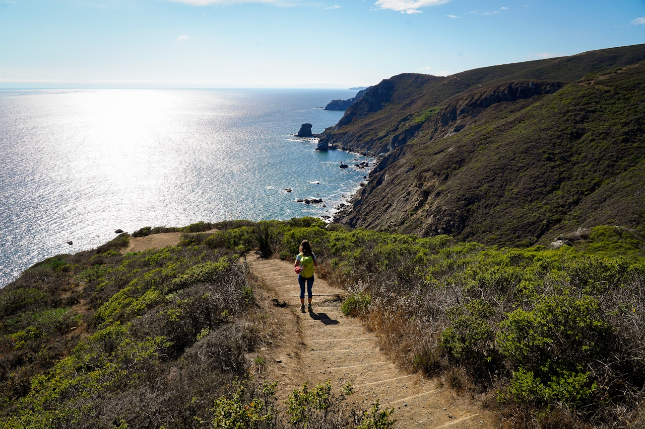 Woman descending dirt steps on the Coastal Trail in the Marin Headlands 