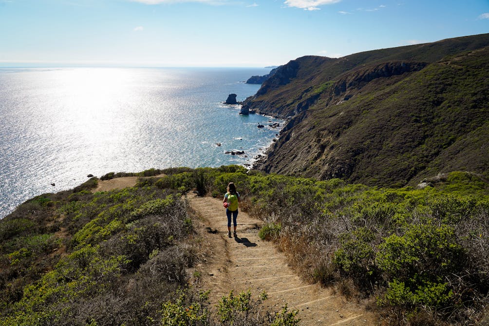 Woman descending dirt steps on the Coastal Trail in the Marin Headlands 