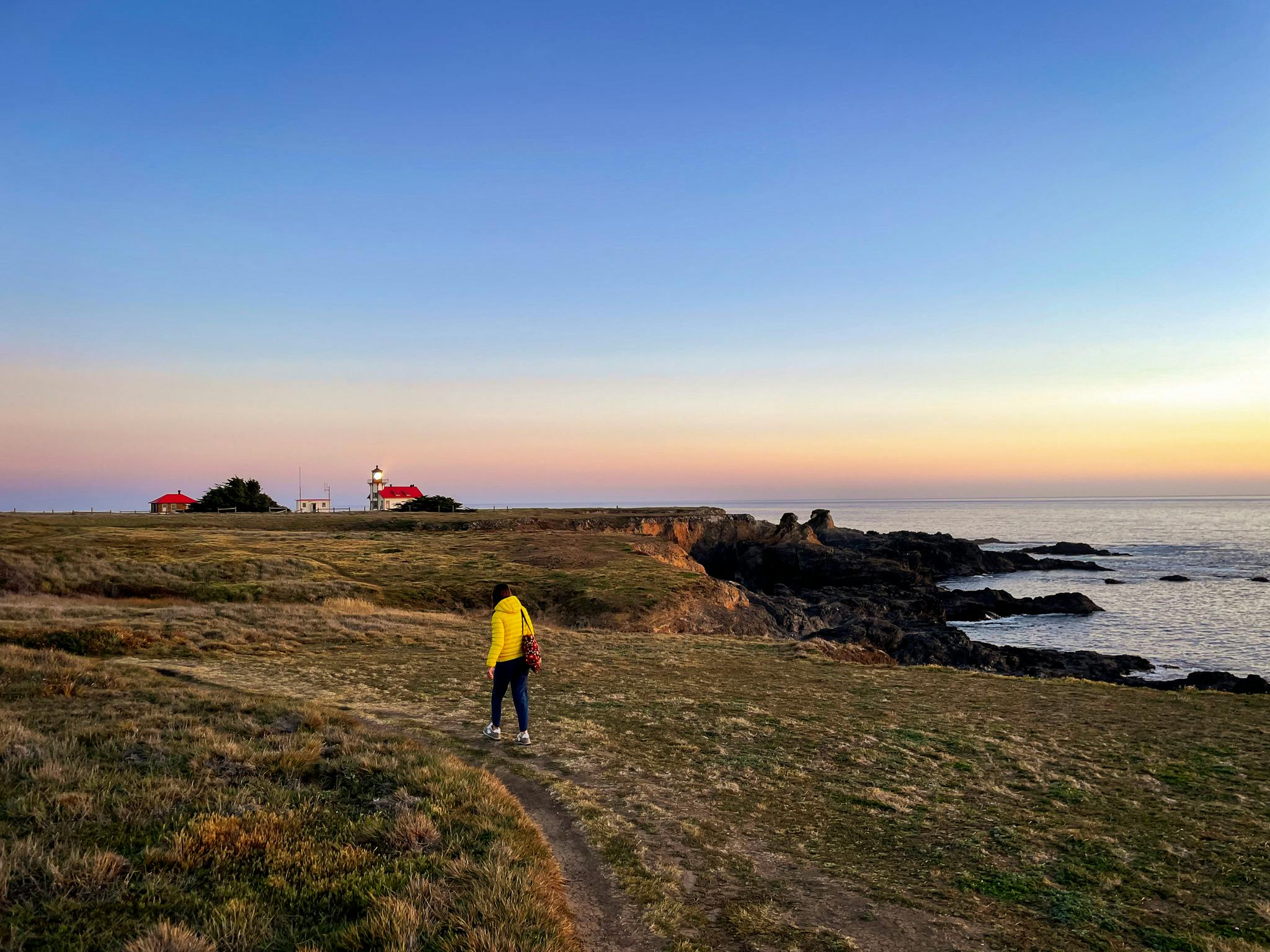 Woman hiking towards Point Cabrillo Light Station on the Mendocino Coast 