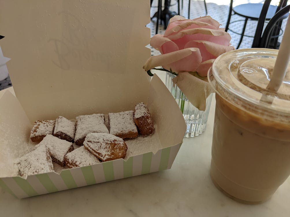 Beignets and an iced drink at a table at Beignet Box in Studio City Los Angeles 