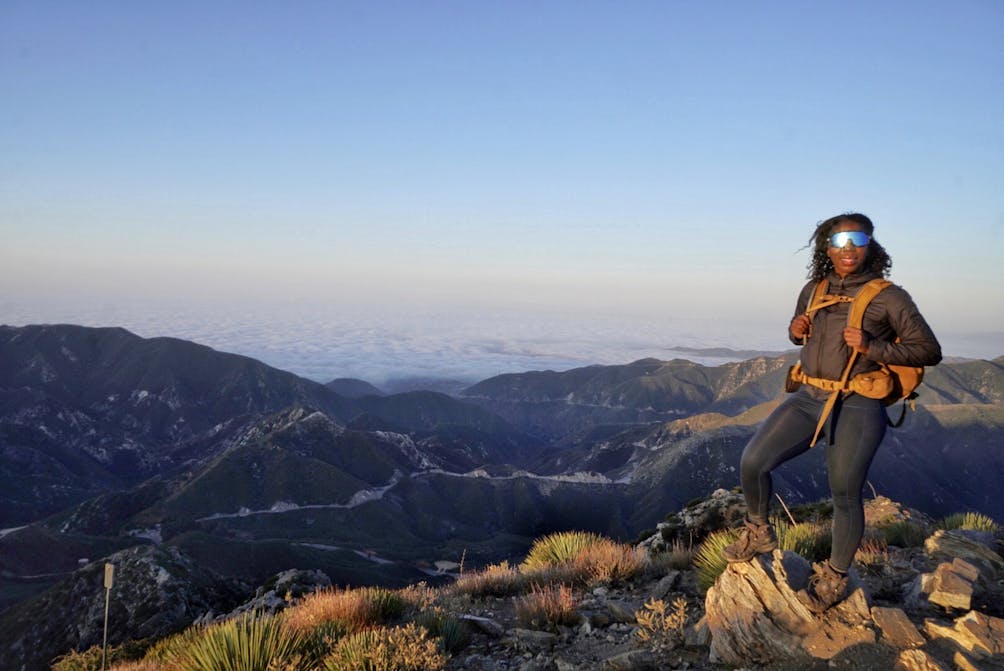 Woman standing at a viewpoint overlooking the San Gabriels at Josephine Peak 