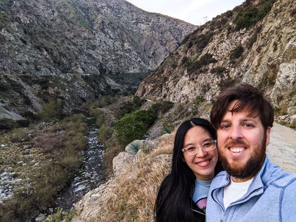 Two hikers taking a selfie photo in front of the San Gabriel River at 