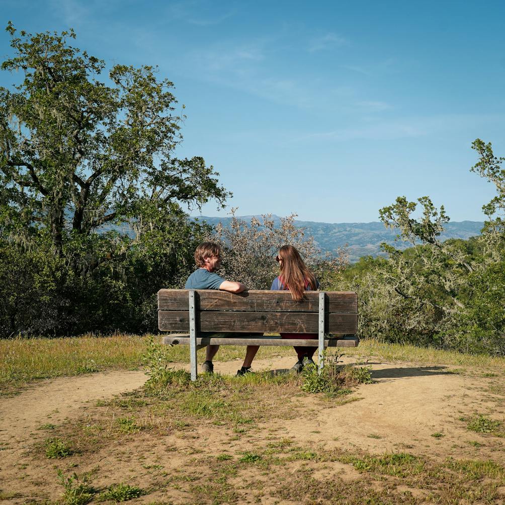 Two people on the Russian River Overlook bench at Healdsburg Ridge Open Space Preserve 