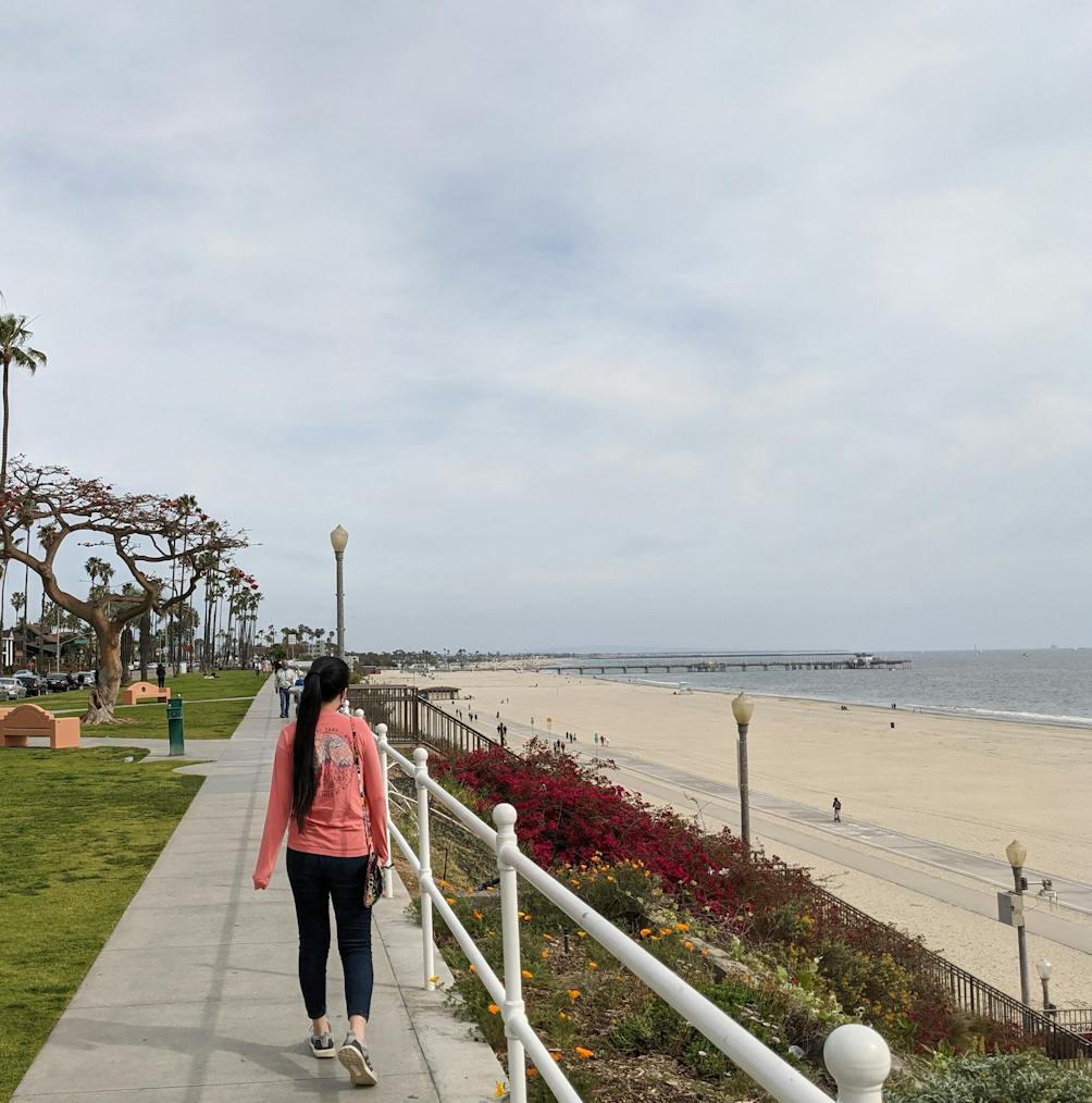 Woman walking along the sidewalk at Long Beach in Los Angeles County 