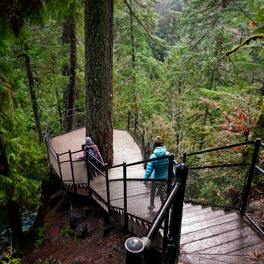 Hiker going down stairs to a viewing platform overlooking Toketee Falls on the Highway of Waterfalls in Southern Oregon 