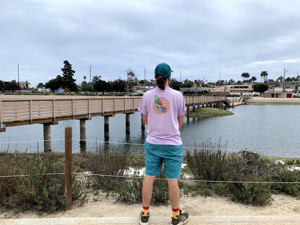 Man looking out towards a bridge at the Colorado Lagoon in Long Beach, Los Angeles County 