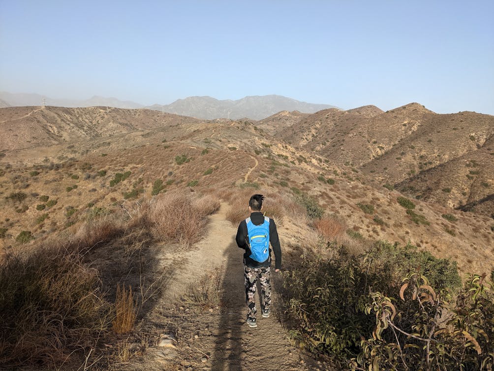 Hiker on the trail at Shadow Hills overlooking the Verdugo Mountains 