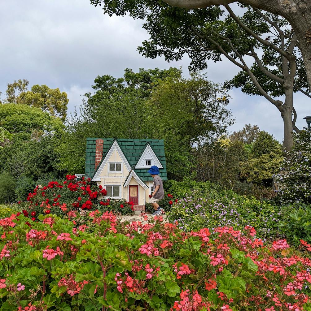Little house in a garden with a little child looking at it in the South Coast Botanic Garden in Ranchos Palos Verdes 