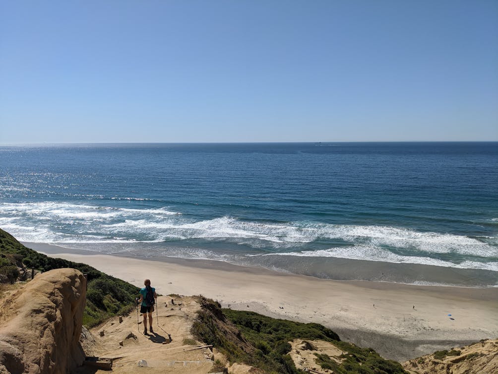 Woman hiking down to Black's Beach in Lo Jolla San Diego 