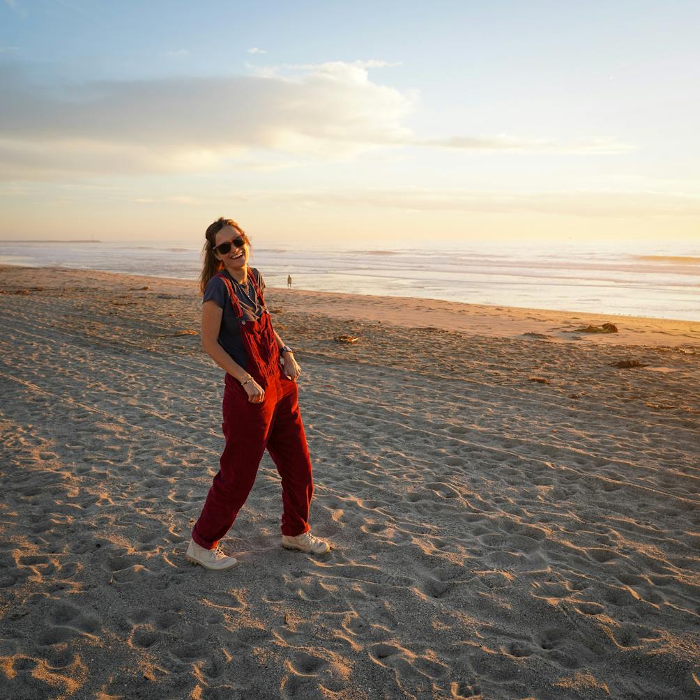 Woman in red overalls enjoying the sunset at Hollywood Beach in Oxnard 