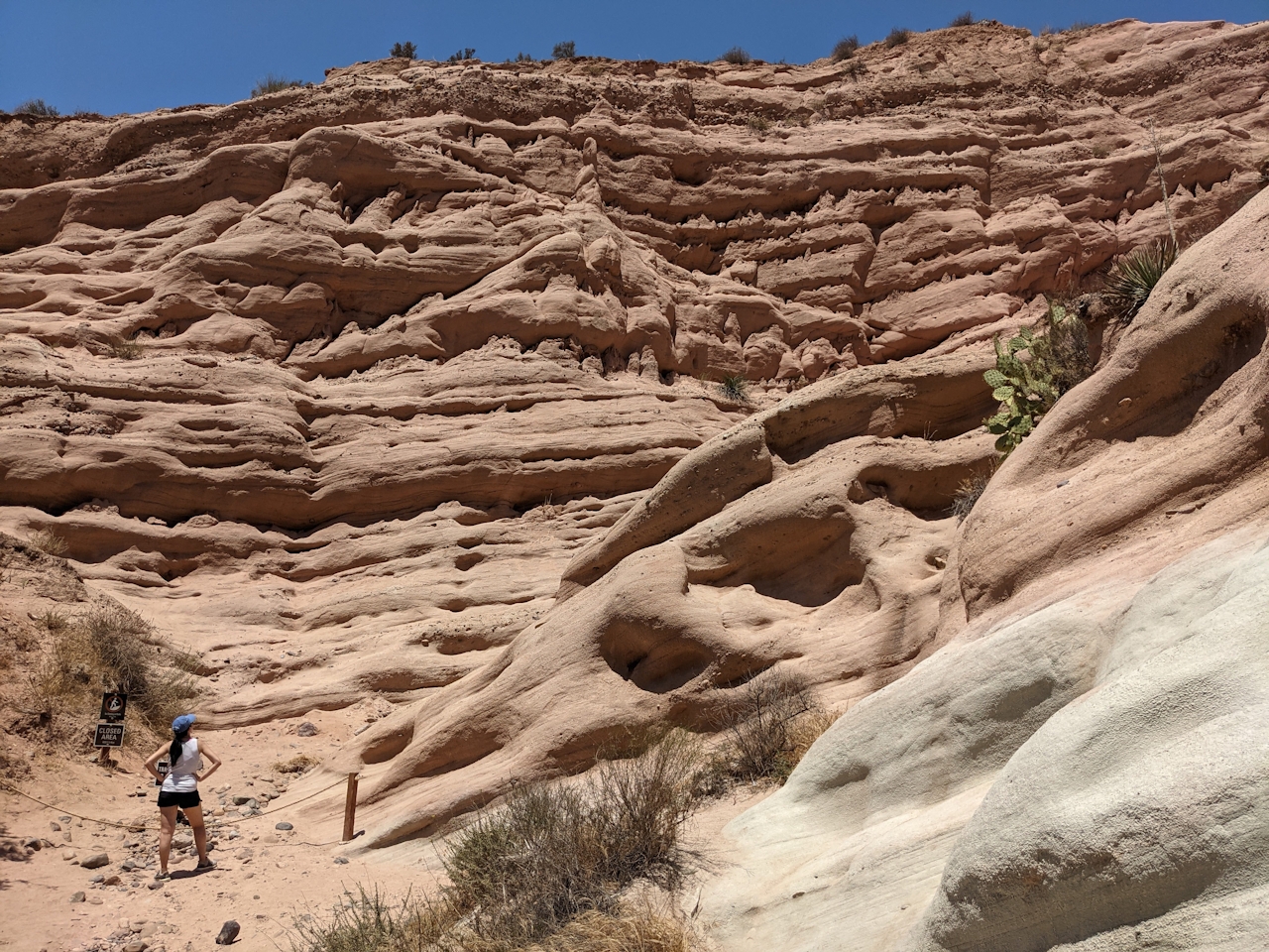 Woman standing at red rock formation in Whiting Ranch Wilderness Park in Orange County 