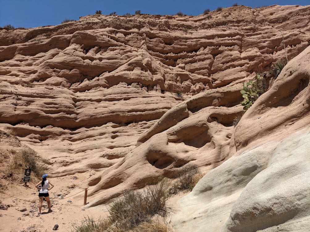 Woman standing at red rock formation in Whiting Ranch Wilderness Park in Orange County 
