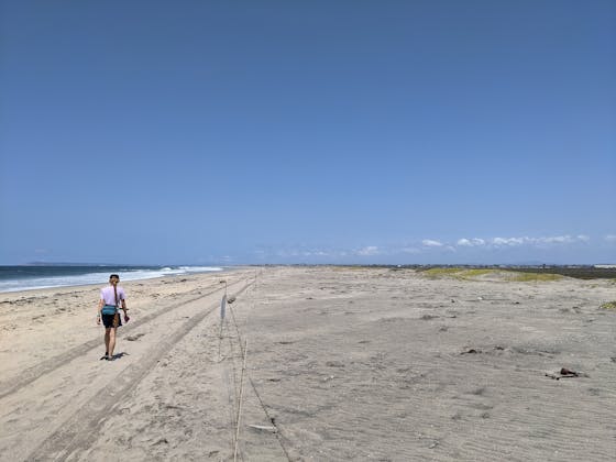 Woman hiking along the vast and open beach at Border Field State Park in Southern California