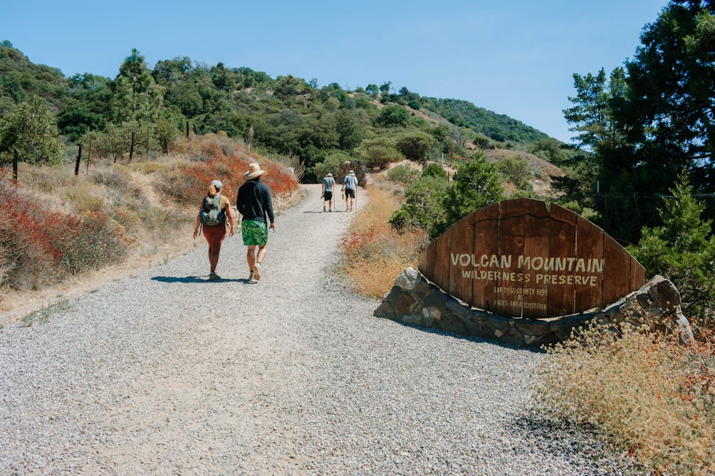 Hikers on a wide trail entering Volcan Mountain Wilderness Preserve near Julian in San Diego County 