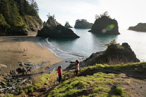 Two hikers making their way down to Secret Beach on the Southern Oregon Coast 