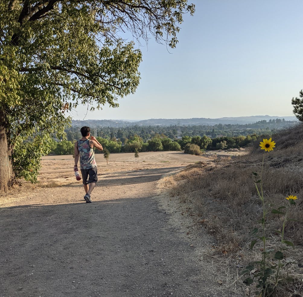 HIker walking a wide trail at Horsethief Canyon Park in San Dimas