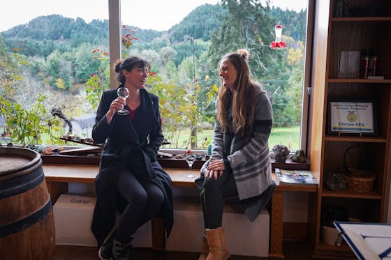 Two women wine tasting in Elkton, Oregon at Rivers Edge Winery