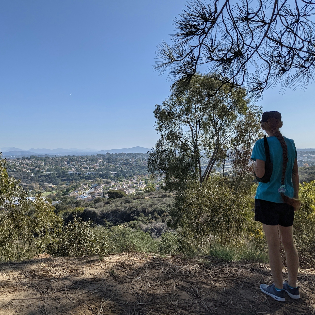 Hiker overlooking the mountain scenery in the distance at Encinitas Ranch in North San Diego County 