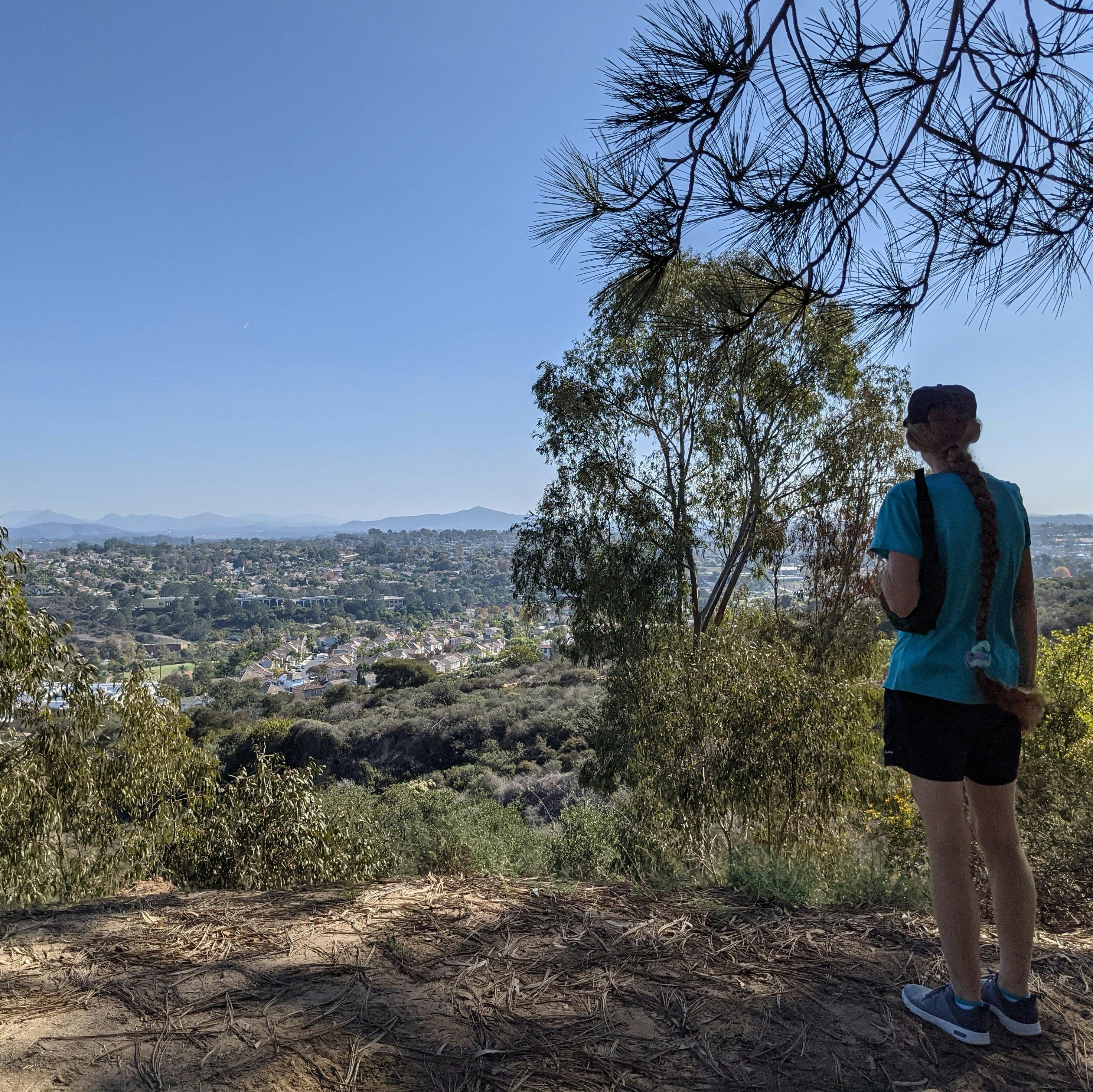 Hiker overlooking the mountain scenery in the distance at Encinitas Ranch in North San Diego County 
