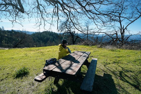 Woman sitting at picnic table at Lawson Picnic spot in Hood Mountain Regional Park Sonoma Valley 