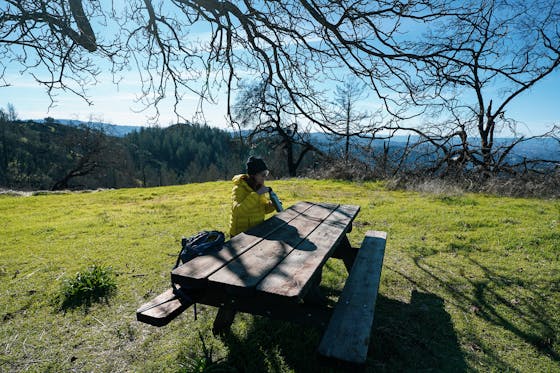 Woman sitting at picnic table at Lawson Picnic spot in Hood Mountain Regional Park Sonoma Valley