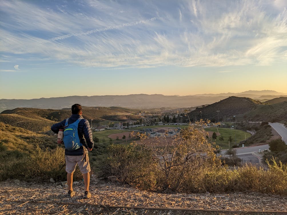 Hiker looking out to huge mountain and sky views at Big Sky Trail in Simi Valley 