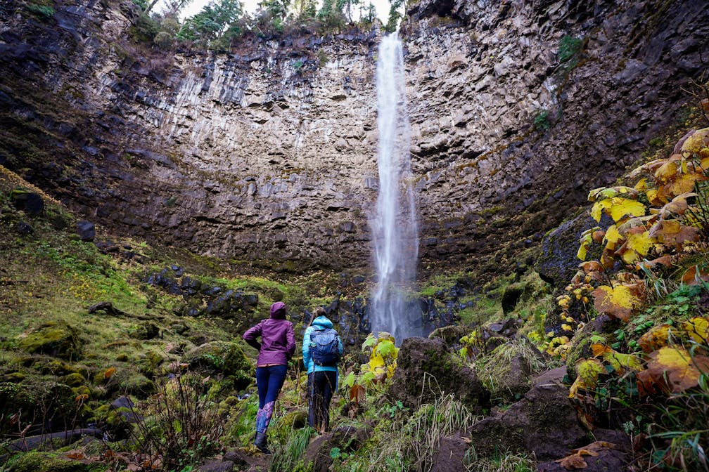Two women looking up at Watson Falls, Southwest Oregon's highest waterfall