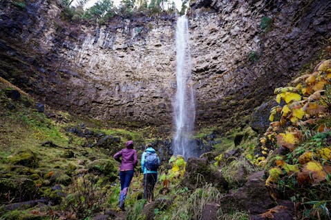 Two women looking up at Watson Falls, Southwest Oregon's highest waterfall 