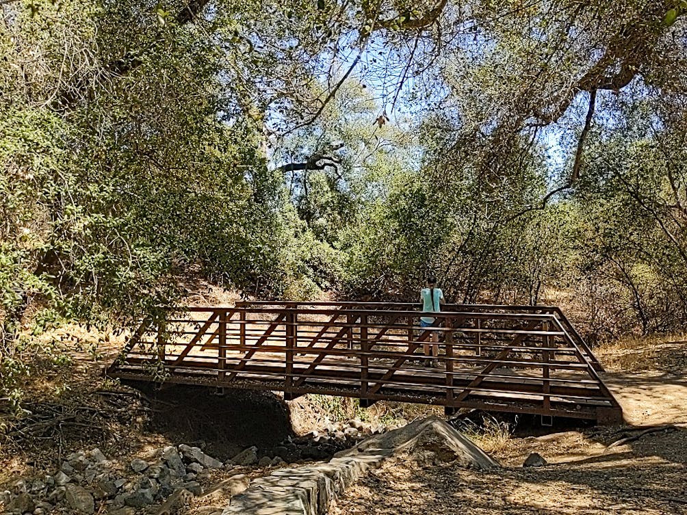 Hiker crossing a bridge at Dos Picos County Park in San Diego County 