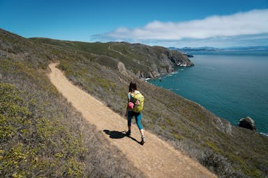 Woman hiking the Coastal Trail paralleling the Pacific Ocean in the Marin Headlands 