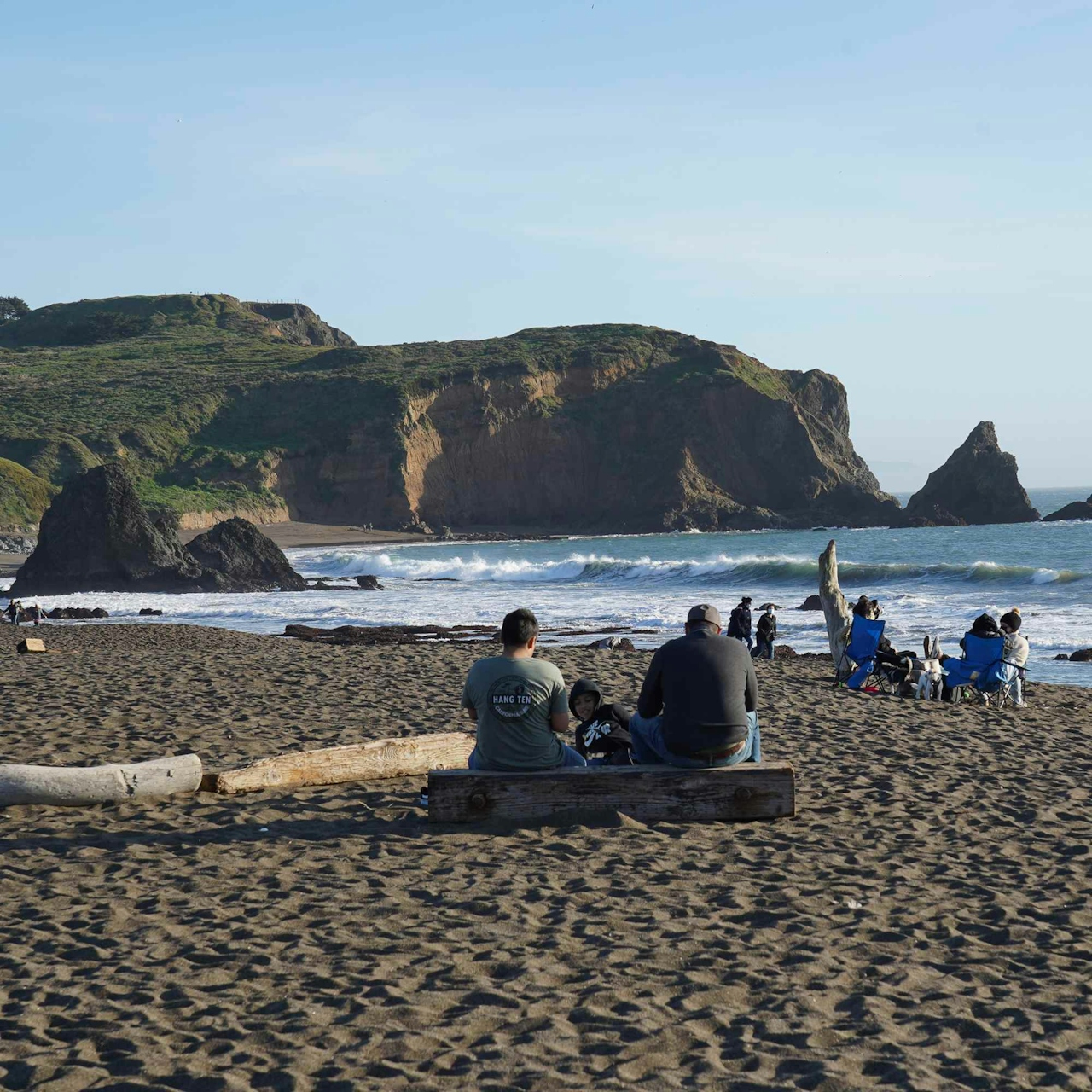 Two people sitting on a log at Muir Beach in the Marin Headlands North Bay 