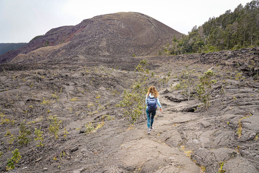 Hiker on an ancient lava field at Hawaii Volcanoes National Park on Kilauea Iki trail