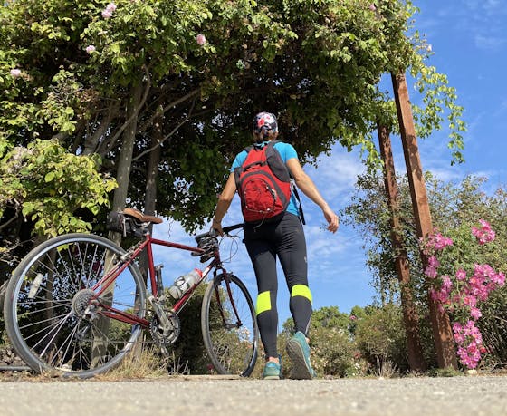 Woman with her bike at entering a garden along Guadalupe River Trail in San Jose