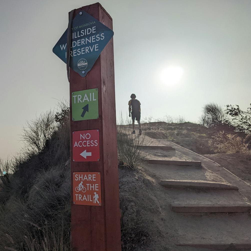 Hiker going up trail stairs at Hillside Wilderness Preserve in Monrovia Los Angeles County 