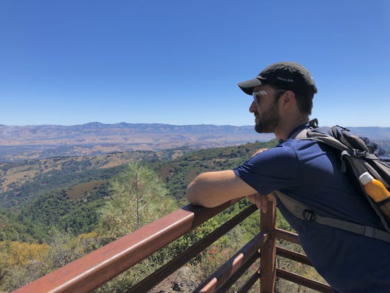 Hiker taking in the mountain view from the summit of Mount Umunhum