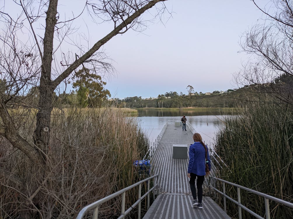 Woman walking onto a dock at Lake Miramar in San Diego 