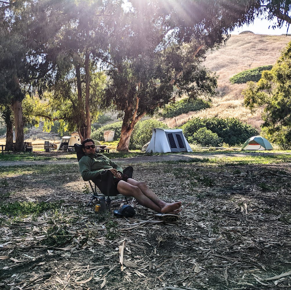Camper sitting in a camp chair at their campsite on Santa Cruz Island Channel Islands National Park 