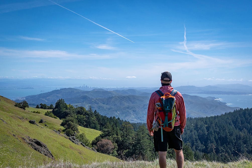 Man standing at Mount Tam vantage overlooking the San Francisco skyline 