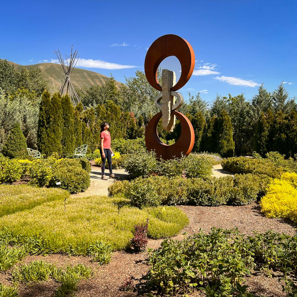 Person in garden looking at sculpture in Sawtooth Botanical Garden in Sun Valley Idaho 
