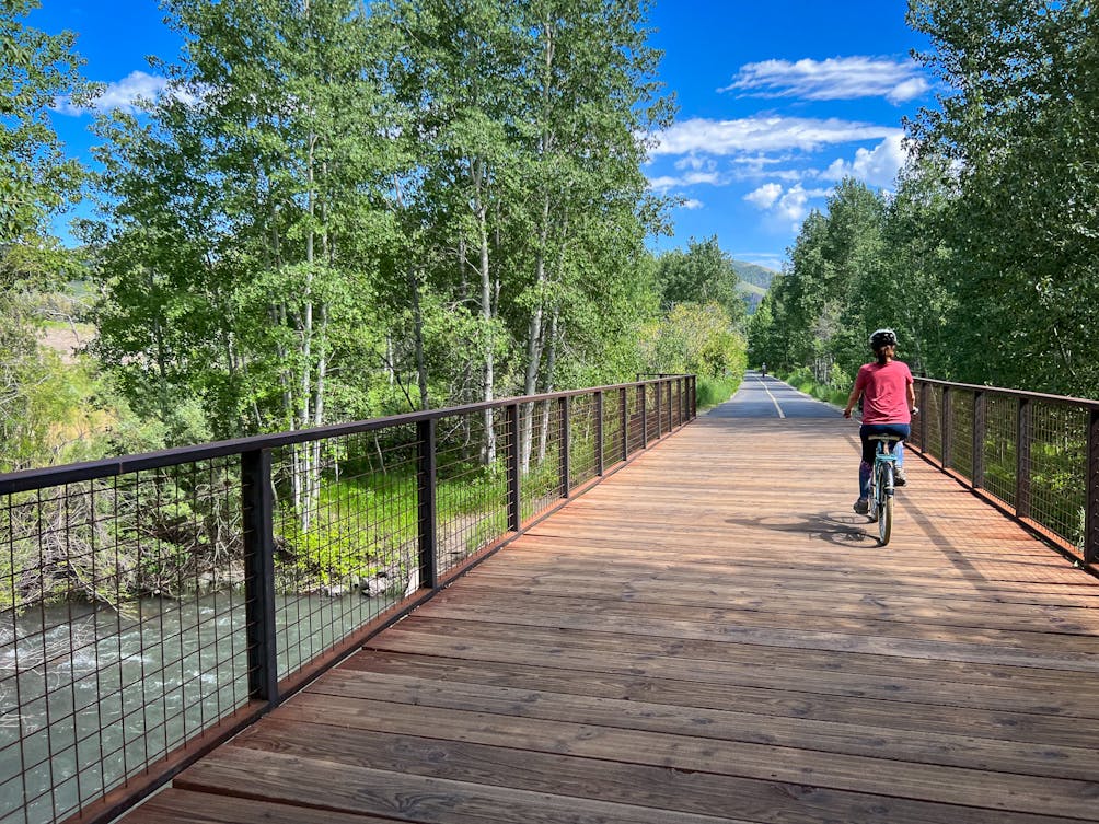 Cyclist crossing a bridge on the Wood River Trail in Sun Valley Idaho 