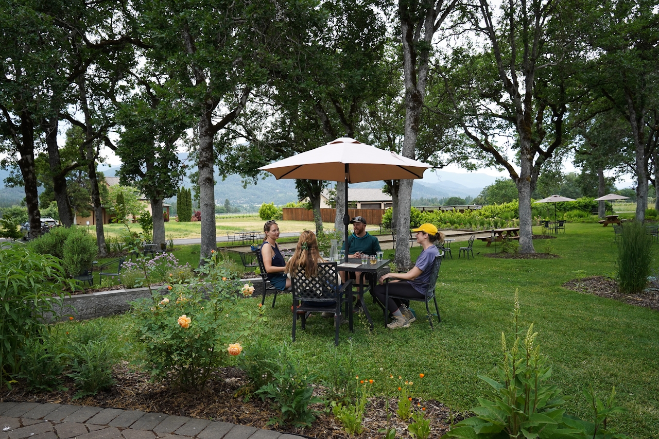 A group of people sitting outside at Troon Vineyard sampling wines in Grants Pass Southern Oregon 