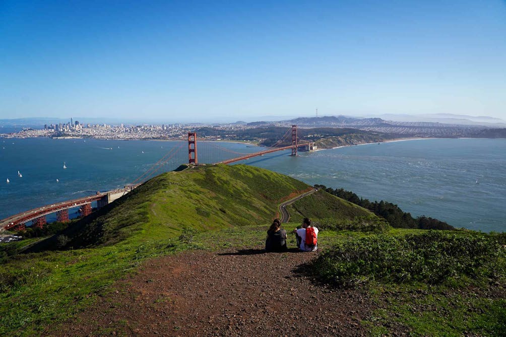 Two people sitting to take in a view of the Golden Gate from the Marin Headlands 