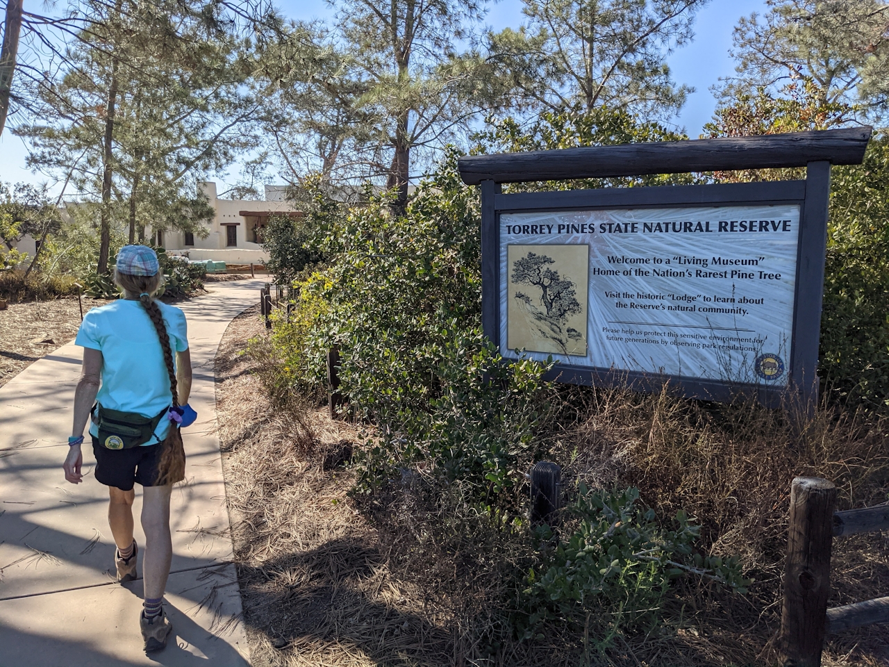 Hiker passing an information sign at Torrey Pines State Natural Reserve in San Diego County 