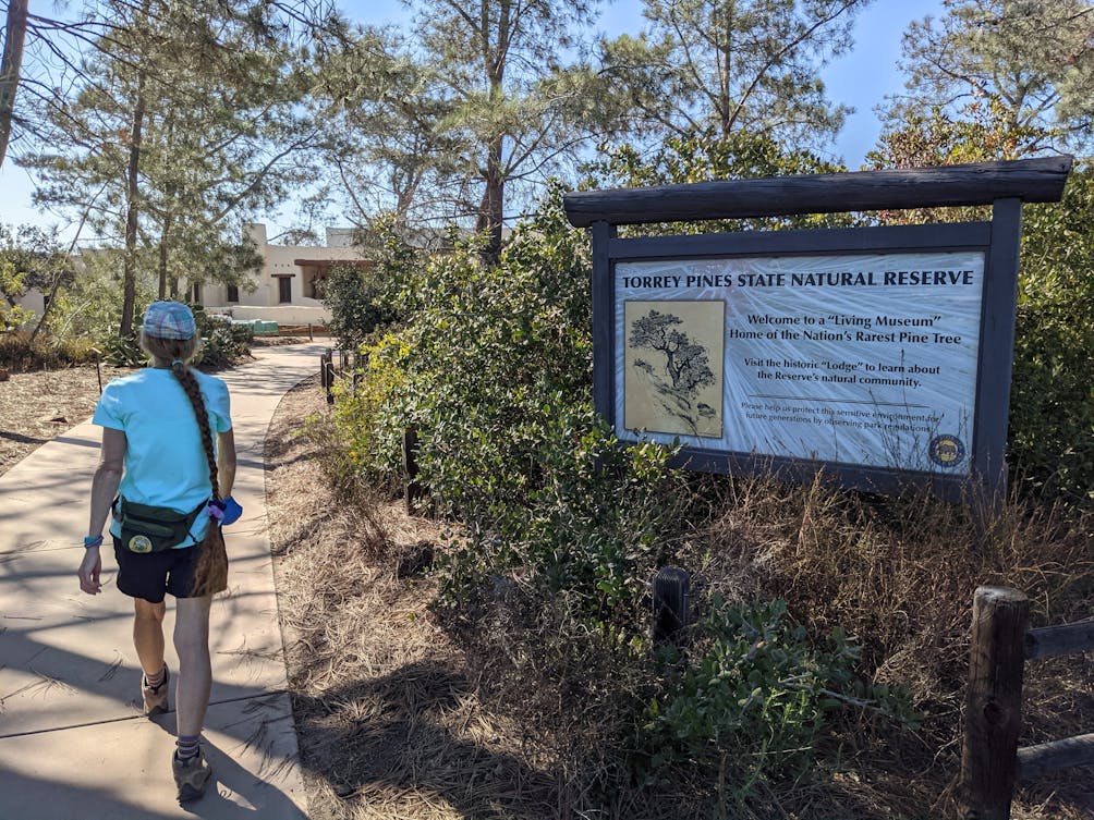 Hiker passing an information sign at Torrey Pines State Natural Reserve in San Diego County 