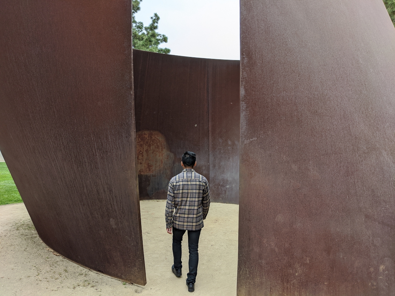 Person walking into a large sculpture at UCLA on campus