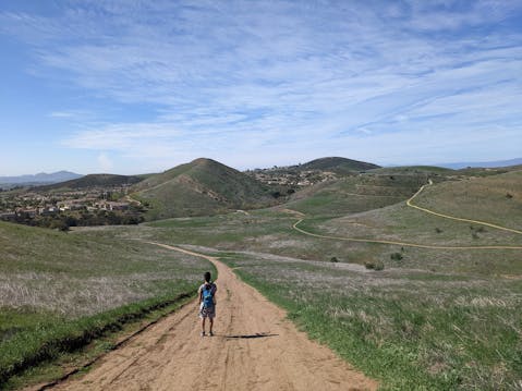 Hiker on a wide open dirt trail at Long Canyon in Simi Valley 