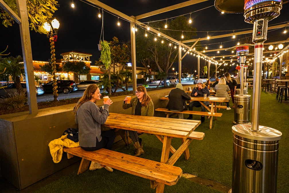 Two women having craft beer at a patio picnic table at Topa Topa in Camarillo