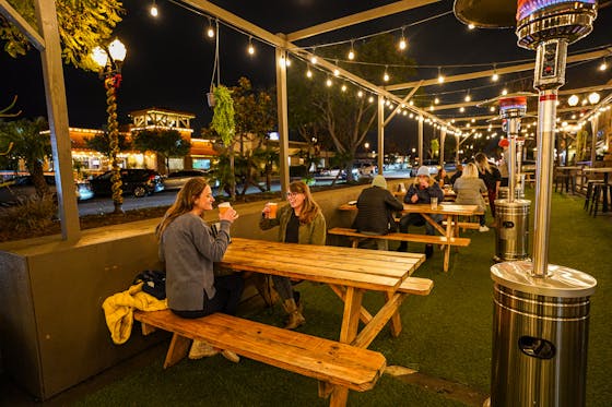 Two women having craft beer at a patio picnic table at Topa Topa in Camarillo