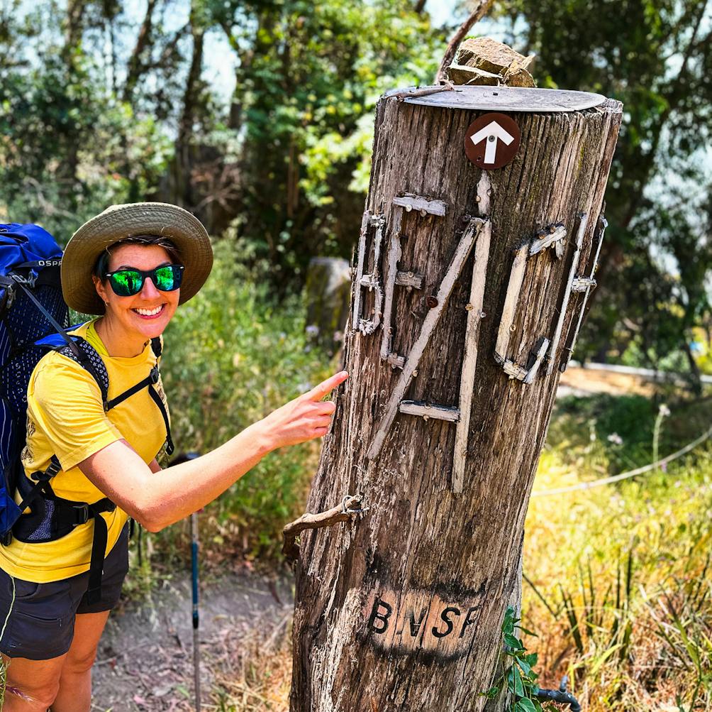 Hiker stopped to pose in front of the stump beach sing at Miller Knox Regional Park in the East Bay 